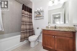 Bathroom featuring a single vanity with wood cabinetry, a light-toned countertop, and a rectangular mirror - 