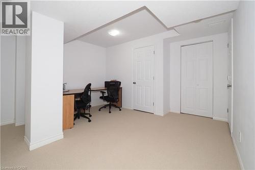 Spacious room featuring neutral carpeting, white walls, and bright overhead lighting - 213 Seabrook Drive, Kitchener, ON 