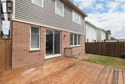 Rear exterior showcasing a wood deck, brick and siding facade, and sliding glass patio doors - 
