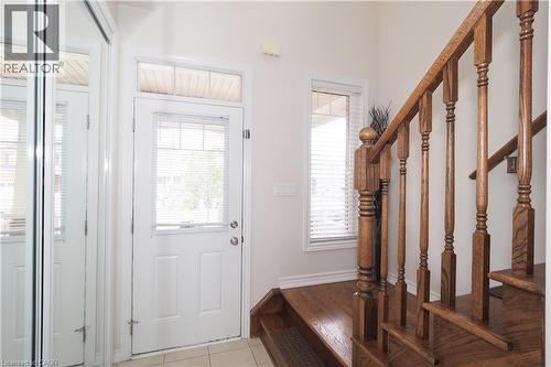 Entryway featuring a paneled door with an overhead transom window, a side window, and mirrored closet doors - 213 Seabrook Drive, Kitchener, ON 