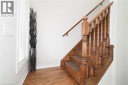 Hardwood staircase featuring wood-finish treads and risers, turned newel post, and balusters - 