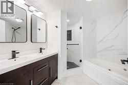 Double vanity with dark wood-finish cabinetry, white countertops, and matte black fixtures - 