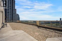 Expansive outdoor terrace featuring paver flooring and a partial concrete surface - 