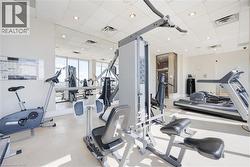 Fitness center featuring expansive floor-to-ceiling windows, mirrored wall, recessed lighting, drop ceiling, and light-toned flooring - 
