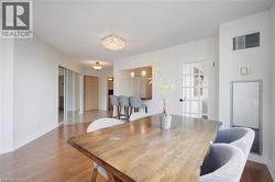 Bright interior space featuring wood-finish flooring, a contemporary chandelier, a white French paneled door, and a built-in breakfast bar with pendant lighting - 
