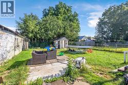 Expansive backyard featuring a combination of grass and concrete patio space - 