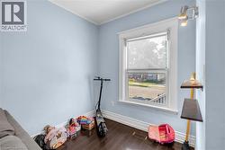 Room with light blue walls and dark wood-finish flooring - 
