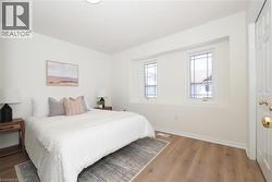 White-painted room featuring wood-finish flooring and two windows with decorative grilles - 