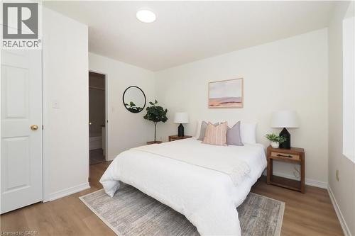 Bedroom featuring wood-finish flooring, white walls, and a ceiling-mounted light fixture - 619 Wild Ginger Avenue Unit# H47, Waterloo, ON - Indoor Photo Showing Bedroom
