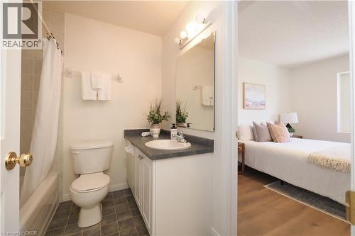 Bathroom featuring a white vanity with a dark countertop, an integrated sink, and a mirrored medicine cabinet with overhead lighting - 619 Wild Ginger Avenue Unit# H47, Waterloo, ON - Indoor Photo Showing Bathroom