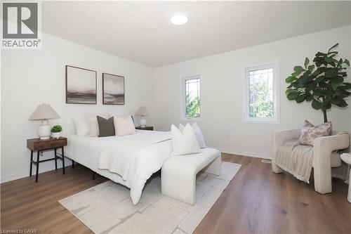 Spacious room featuring wood-finish flooring, white walls, and a recessed ceiling light - 619 Wild Ginger Avenue Unit# H47, Waterloo, ON - Indoor Photo Showing Bedroom