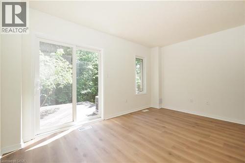 Bright interior space featuring wood-finish flooring and white walls - 619 Wild Ginger Avenue Unit# H47, Waterloo, ON - Indoor Photo Showing Other Room