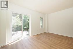 Bright interior space featuring wood-finish flooring and white walls - 