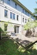 Exterior multi-level residence featuring a wood deck, stone base, vertical siding, and multiple windows - 