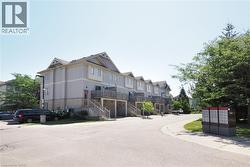 Multi-level townhouse-style units featuring light-colored siding, dark roofing, and individual balconies - 