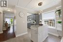 Kitchen area featuring gray cabinetry, a white movable island, a window with a cellular shade, and built-in shelving - 520 Mayflower Street, Waterloo, ON  - Indoor 