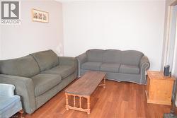 Spacious room featuring light-toned walls and wood-finish flooring - 