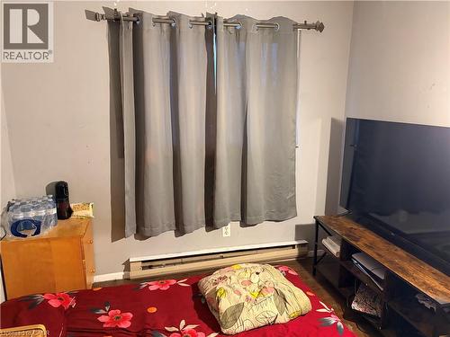 Interior room featuring neutral wall paint, wood-finish flooring, and a baseboard heating unit - 249 Cedarbrae Avenue Unit# 1, Waterloo, ON 