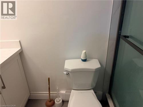 Bright white walls complement a contemporary toilet and a glass-enclosed shower featuring dark bronze trim - 249 Cedarbrae Avenue Unit# 1, Waterloo, ON 