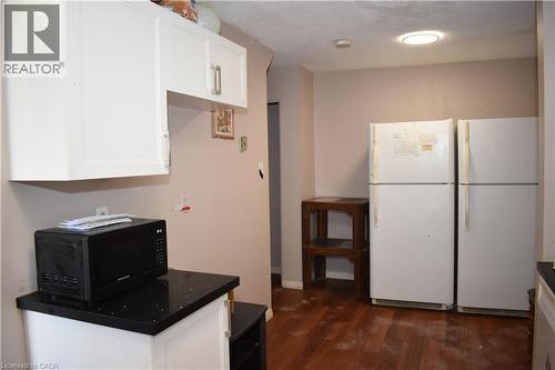 Kitchen area featuring white cabinetry with brushed nickel hardware, dark speckled countertops, and wood-finish flooring - 249 Cedarbrae Avenue Unit# 1, Waterloo, ON 