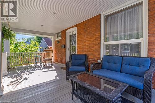 Covered front porch featuring a white spindle railing and wood-finish flooring - 630 Lawrence Street, Cambridge, ON - Outdoor With Deck Patio Veranda With Exterior