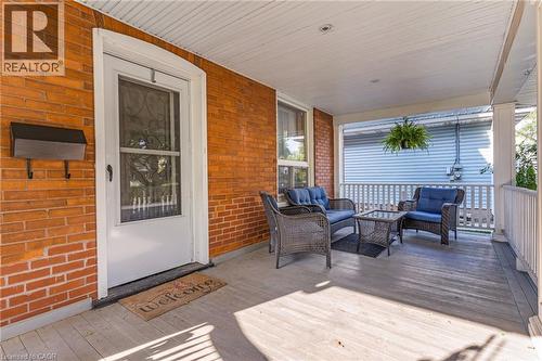 Covered front porch featuring wood-finish flooring, a white spindle railing, and a beadboard ceiling - 630 Lawrence Street, Cambridge, ON - Outdoor With Deck Patio Veranda With Exterior