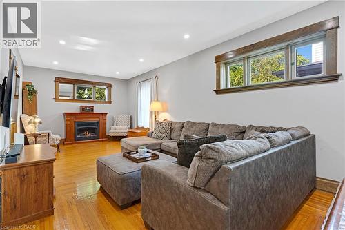 Bright living area featuring wood-finish flooring, recessed lighting, and a prominent fireplace with a detailed wood mantel - 630 Lawrence Street, Cambridge, ON - Indoor Photo Showing Living Room With Fireplace