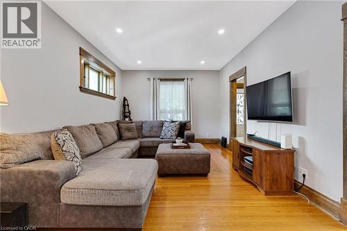 Spacious living area featuring polished wood-finish flooring, recessed lighting, and a window with wood trim - 630 Lawrence Street, Cambridge, ON - Indoor Photo Showing Living Room