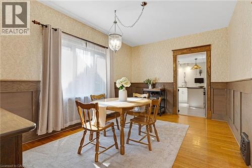Dining area featuring wood-finish flooring, wainscoting, and patterned wallpaper - 630 Lawrence Street, Cambridge, ON - Indoor Photo Showing Dining Room