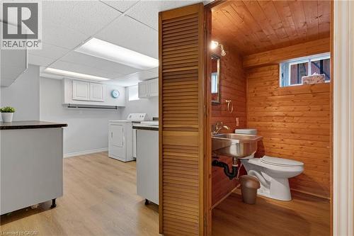 Laundry area featuring wood-finish flooring, white cabinetry, a drop ceiling with recessed lighting, and a utility sink - 630 Lawrence Street, Cambridge, ON - Indoor