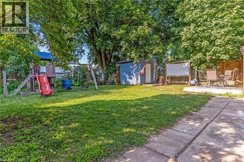 Expansive green lawn surrounded by mature trees, featuring a concrete patio area - 630 Lawrence Street, Cambridge, ON - Outdoor