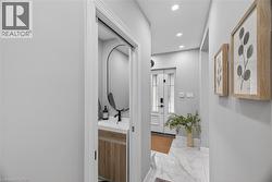Entryway featuring a white paneled front door with glass inserts, recessed lighting, and large format marble-look floor tiles - 