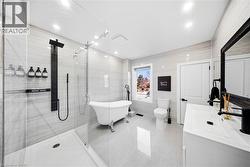 Bathroom with vanity, tile walls, a freestanding tub, a shower stall, and light tile patterned floors - 