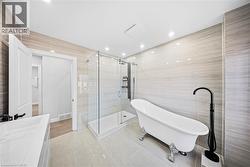 Bathroom with tile walls, a stall shower, vanity, a soaking tub, and light tile patterned floors - 