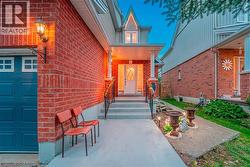 Brick exterior featuring a blue garage door with window inserts, a covered front porch, and a decorative front door with transom window - 