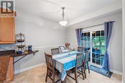 Dining area featuring light tile flooring, crown molding, and a modern ceiling fixture - 