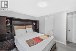 Bedroom with light gray walls and contemporary light wood-finish flooring - 