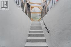 Concrete staircase with a metal handrail and adjacent retaining walls - 