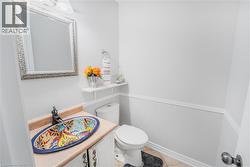 Vanity with an ornate vessel sink, single-handle faucet, and framed mirror - 