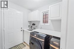 Utility room featuring white cabinetry, a sink basin with a faucet, and a countertop space - 