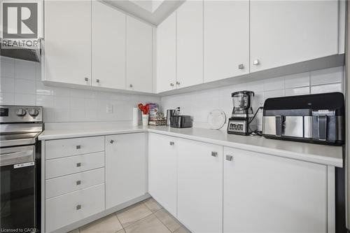 Contemporary kitchen featuring white cabinetry, a white subway tile backsplash, light-toned countertops, stainless steel appliances, and tile flooring - 240 Velvet Way, Niagara Falls, ON - Indoor Photo Showing Kitchen
