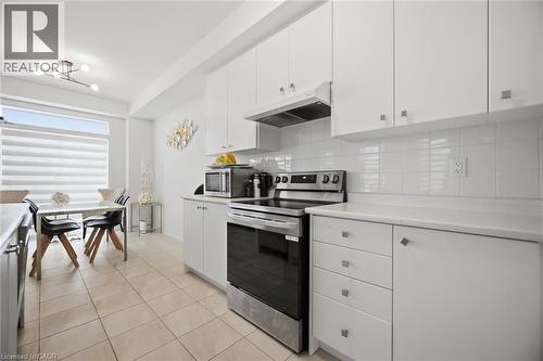 Kitchen featuring white flat-panel cabinetry, white countertops, tile backsplash, and stainless steel appliances - 240 Velvet Way, Niagara Falls, ON - Indoor Photo Showing Kitchen