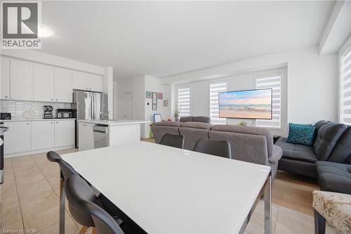 Open-concept living space with a contemporary kitchen featuring white cabinetry and stainless steel appliances - 240 Velvet Way, Niagara Falls, ON - Indoor