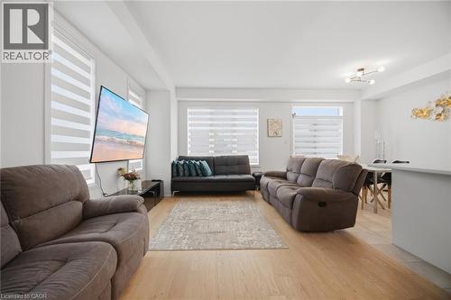 Open-concept living area featuring light wood-finish flooring, white walls, and multiple windows with horizontal blinds - 240 Velvet Way, Niagara Falls, ON - Indoor Photo Showing Living Room