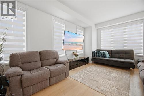 Living area featuring light wood-finish flooring, white walls, and multiple windows with horizontal blinds - 240 Velvet Way, Niagara Falls, ON - Indoor Photo Showing Living Room