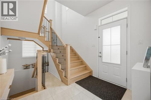Entryway featuring a light wood-finish staircase with black iron spindles, a white paneled door with frosted glass inserts, and a transom window - 240 Velvet Way, Niagara Falls, ON - Indoor Photo Showing Other Room