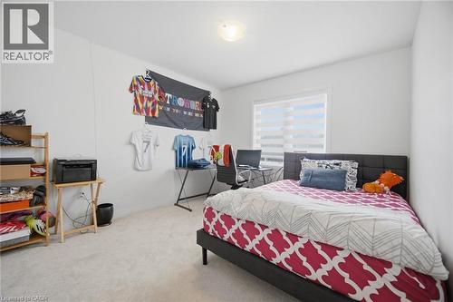 Carpeted room with a ceiling-mounted light fixture, a window with horizontal blinds, and white walls - 240 Velvet Way, Niagara Falls, ON - Indoor Photo Showing Bedroom