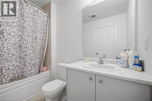 Bathroom featuring a white bathtub, tiled shower surround, commode, and a vanity with a surface-mount sink and light-toned countertop - 240 Velvet Way, Niagara Falls, ON - Indoor Photo Showing Bathroom