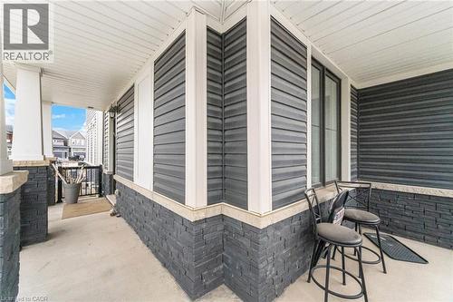 Covered porch featuring dark siding and stone veneer accents - 240 Velvet Way, Niagara Falls, ON - Outdoor With Exterior