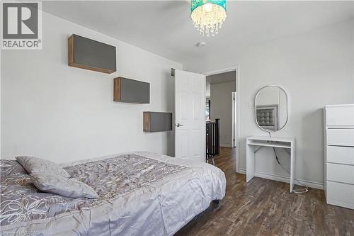 Interior room featuring wood-finish flooring, white walls, and a chandelier-style ceiling light - 60 Postmaster Drive, Kitchener, ON - Indoor Photo Showing Bedroom